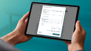 Hände halten ein Tablet mit geöffnetem thevea-Dialog zur Zuzahlungserfassung einer Patientin, inklusive Maßnahmen, Summe und Zahlungsauswahl.